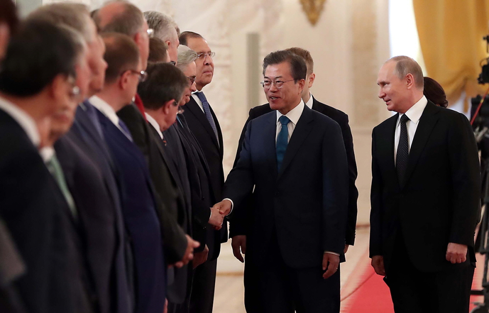 President Moon Jae-in (second from right) is escorted by Russian President Vladimir Putin (right) as he greets Russian ministers during a welcome ceremony at the Kremlin on June 22.