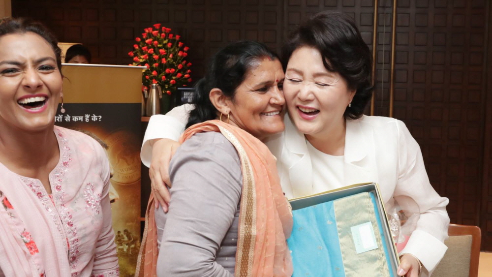 First lady Kim Jung-sook embraces Daya Kaur, the mother of the Phogat family, after exchanging gifts at a hotel in New Delhi on July 10.