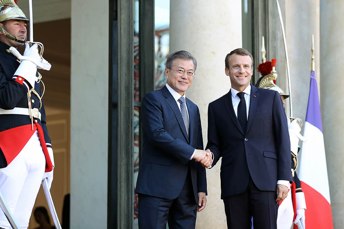 President Moon Jae-in (left) and French President Emmanuel Macron shake hands after arriving at Élysée Palace in Paris on Oct. 15.