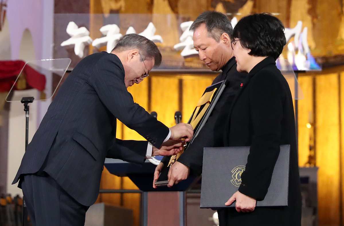 President Moon Jae-in (left) on Dec. 10 awards the Rose of Sharon Medal to the bereaved family of the late lawmaker Roh Hoe-chan during a ceremony marking Human Rights Day at the Seoul Cathedral of the Anglican Church of Korea.