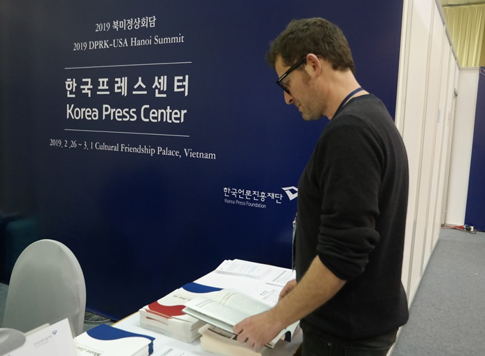 A journalist on Feb. 26 reads an English-language book on President Moon Jae-in’s achievements published by the Korean Culture and Information Service at the front desk of the Korea Press Center within the IMC in Hanoi, Vietnam.