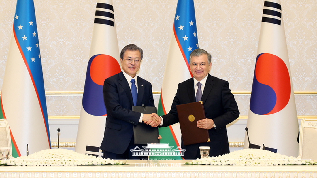 President Moon Jae-in (left) on April 19 shakes hands with Uzbek President Shavkat Miriziyoyev at a signing ceremony after their bilateral summit.