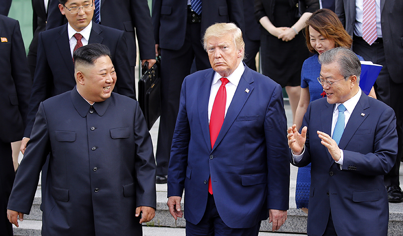 U.S. President Donald Trump, North Korean leader Kim Jong Un and President Moon Jae-in walk together on June 30 before the U.S.-North Korea summit held at Freedom House in the truce village of Panmunjeom. (Yonhap News)