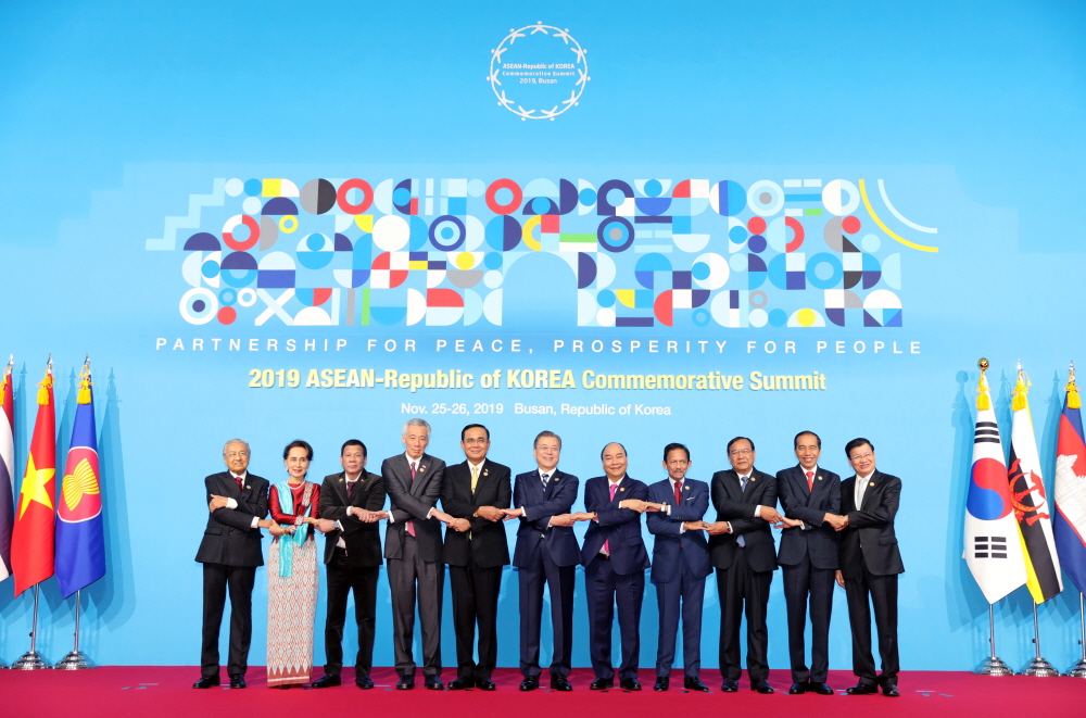 President Moon Jae-in (sixth from left) on Nov. 26 poses for group photos while holding hands with leaders from the ten ASEAN member states at the 2019 ASEAN-ROK Commemorative Summit at BEXCO in Busan. From left are Malaysian Prime Minister Mahathir Mohamad, Myanmar State Counsellor Aung San Suu Kyi, Philippine President Rodrigo Duterte, Singaporean Prime Minister Lee Hsien Loong, Thai Prime Minister Prayut Chan-o-cha, President Moon, Vietnamese Prime Minister Nguyen Xuan Phuc, Bruneian Sultan Hassanal Bolkiah, Cambodian Deputy Prime Minister Prak Sokhonn, Indonesian President Joko Widodo and Lao Prime Minister Thongloun Sisoulith.