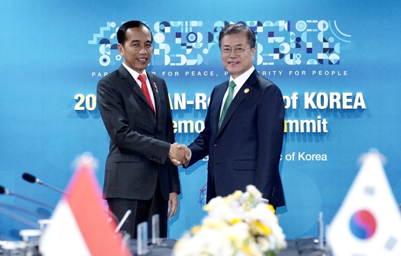 President Moon Jae-in (right) on Nov. 25 shakes hands with Indonesian President Joko Widodo before their bilateral summit in Busan. 