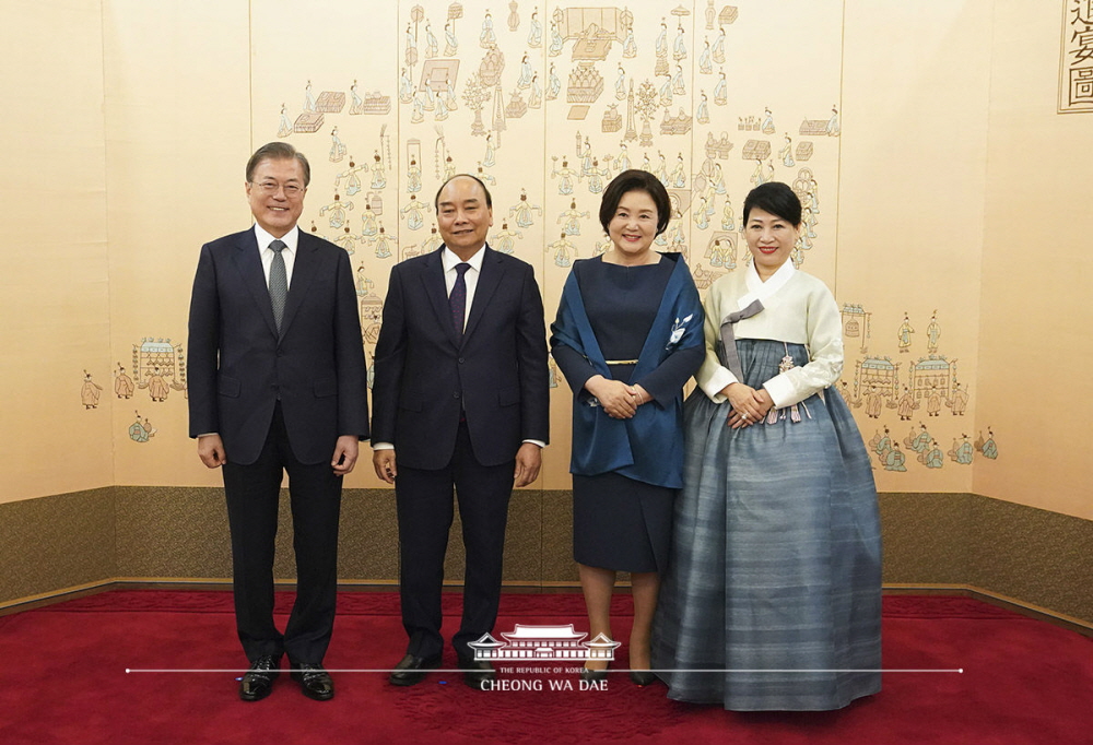 President Moon Jae-in and first lady Kim Jung-sook on Nov. 27 take photos with Vietnamese Prime Minister Nguyen Xuan Phuc and his wife Tran Thi Nguyet Thu at a welcoming banquet at Cheong Wa Dae. Wearing the Hanbok she received as a gift, Thu said, "It's really pretty. I feel like I've become the Vietnamese Daejanggeum (a character from a hit historical Korean drama). From left are President Moon, Phuc, Kim and Thu.