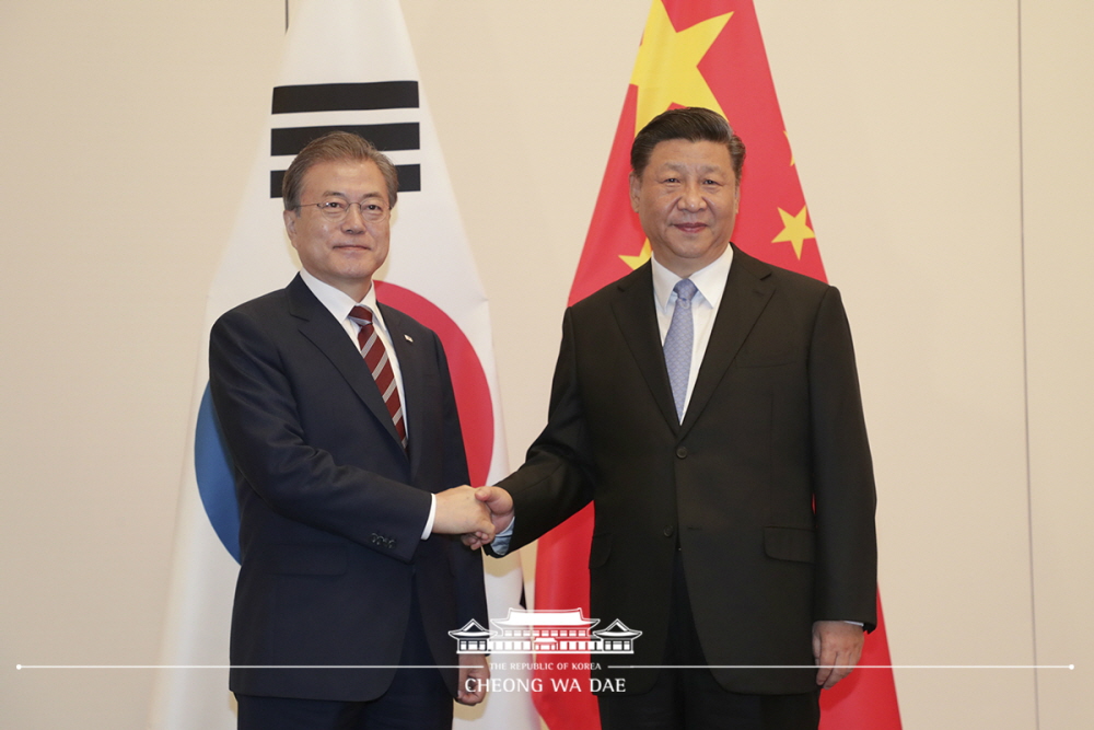 President Moon Jae-in (left) on June 27 shakes hands with Chinese President Xi Jinping before their bilateral talks on the sidelines of the G-20 summit in Osaka Japan.