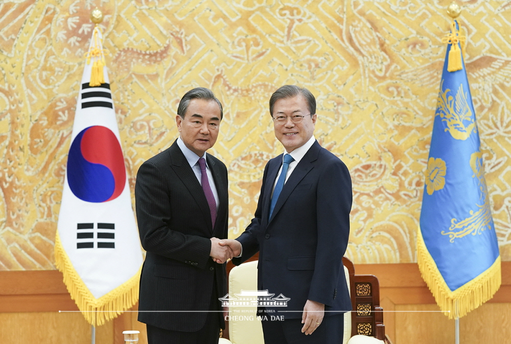 President Moon Jae-in on Dec. 5 shakes hands with Chinese Foreign Minister Wang Yi at Cheong Wa Dae. The president later asked Wang for China's continuous support for peace on the Korean Peninsula.