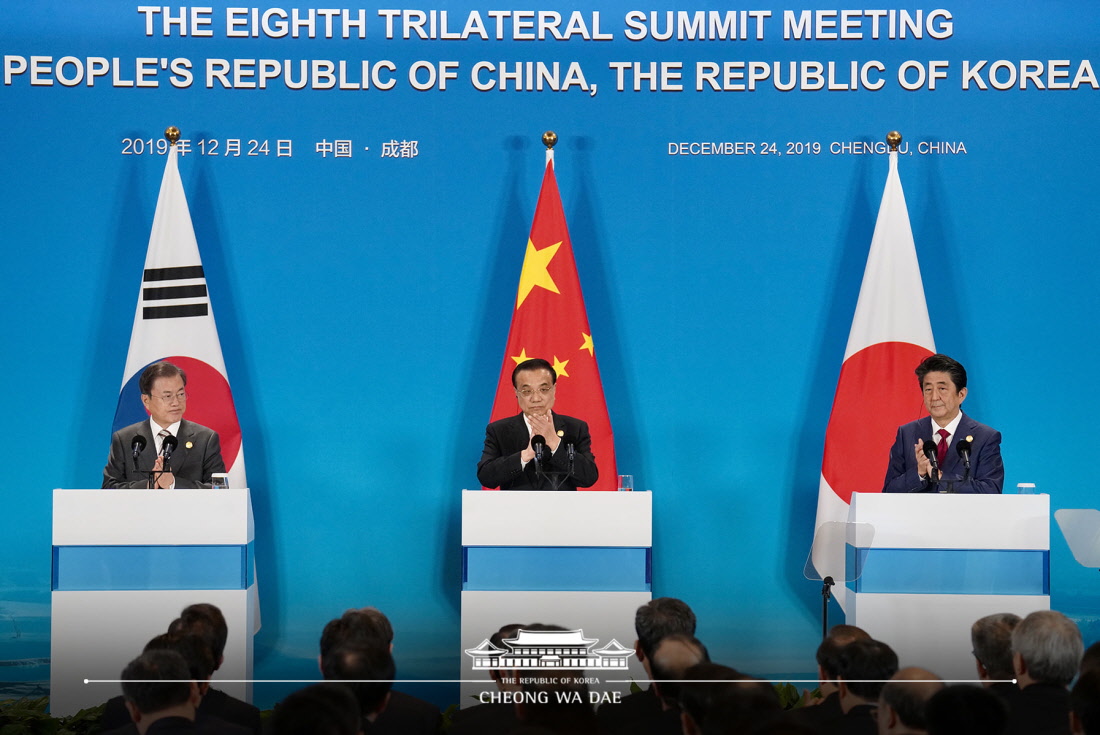 President Moon Jae-in (left) on Dec. 24 speaks at a joint media conference after the eighth trilateral summit among Korea, Japan and China in the latter's city of Chengdu.