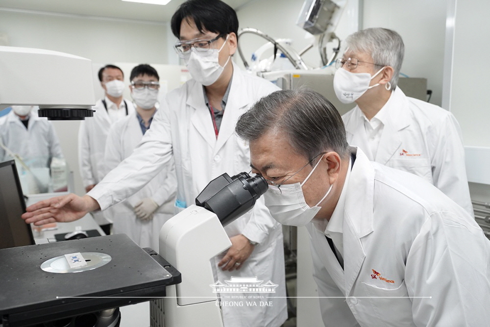 President Moon Jae-in on Oct. 15 observes microscopic cells at the think tank of vaccine company SK Bioscience in Seongnam, Gyeonggi-do Province.