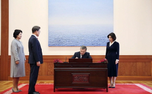 Uzbek President Shavkat Mirziyoyev signing the guestbook and posing for a commemorative photo at Cheong Wa Dae 