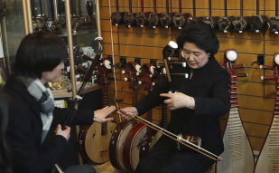 First Lady Kim Jung-sook learning how to play the erhu, a Chinese two-string fiddle 